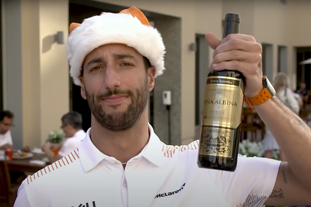 Daniel Ricciardo posa con la botella de vino que le ha regalado Fernando Alonso